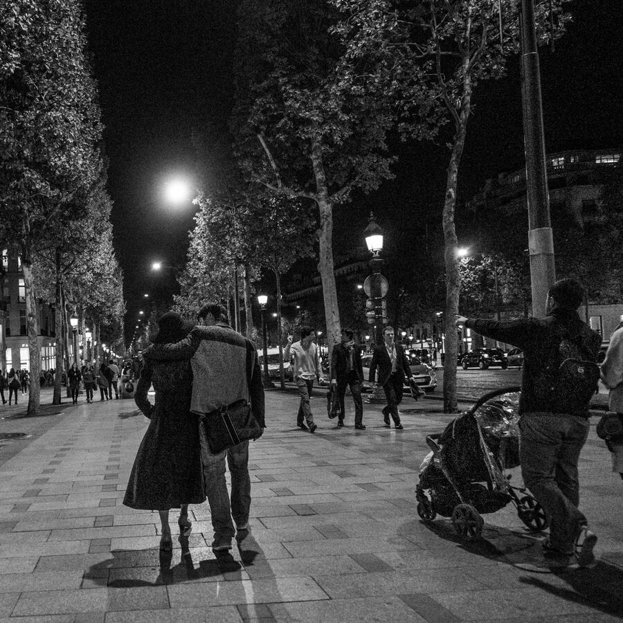 A candid black and white shot in a Woodbridge Walmart. Four women are captured in various standing and squatting poses while browsing the makeup aisle.